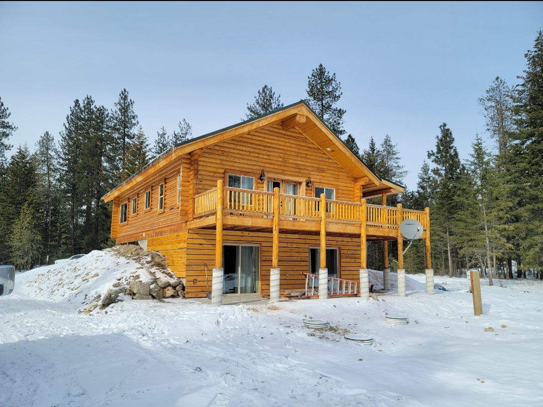 Two-story log home wide view in winter snow