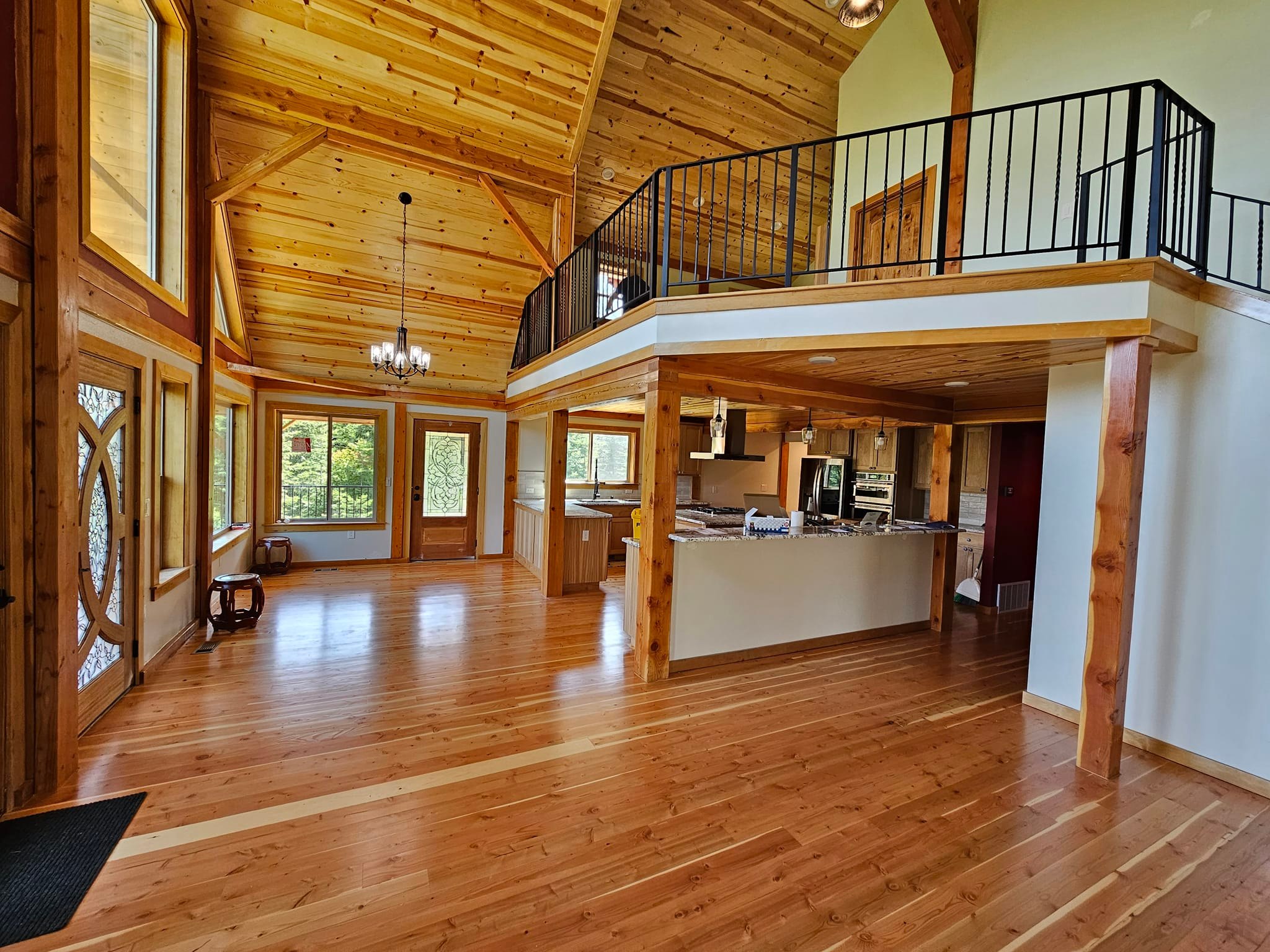 Open concept log home living area with loft